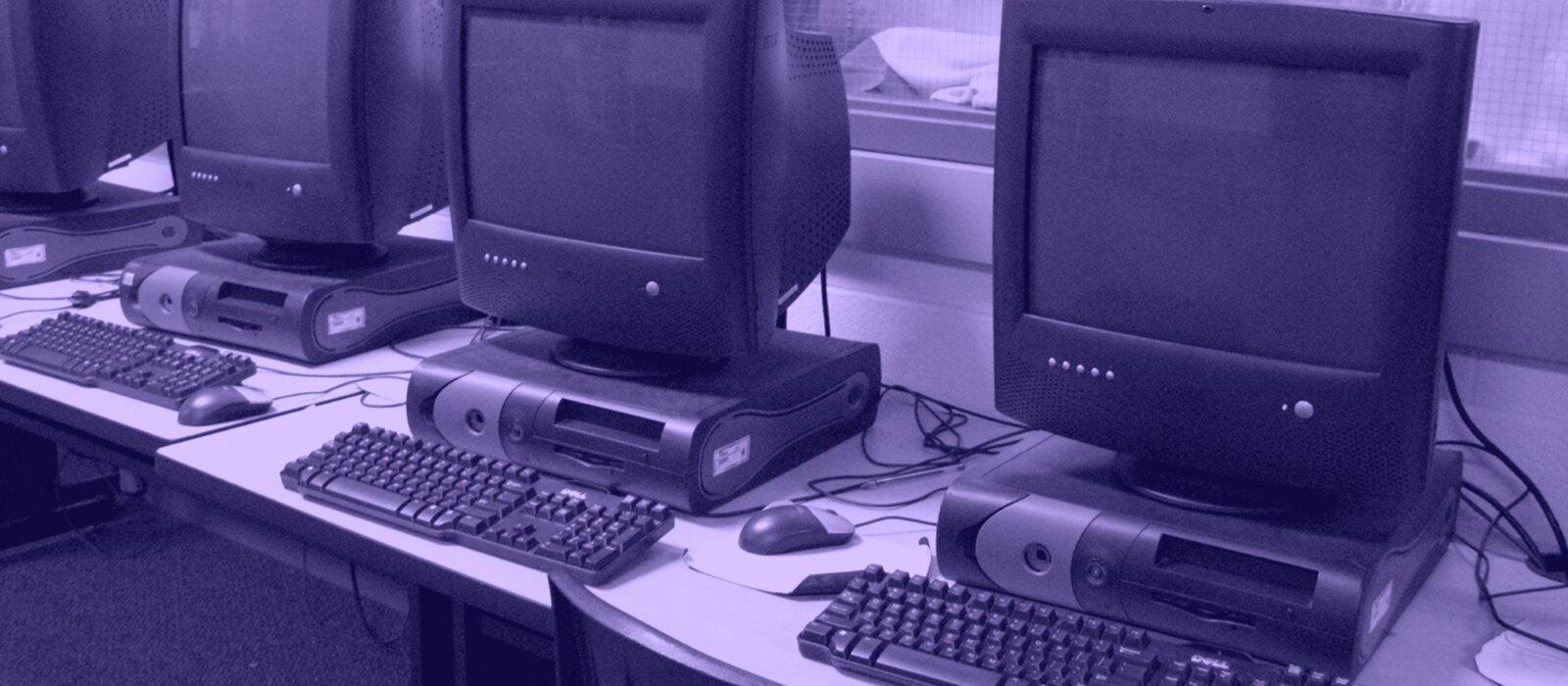 A room of beige desktop computers and CRT monitors